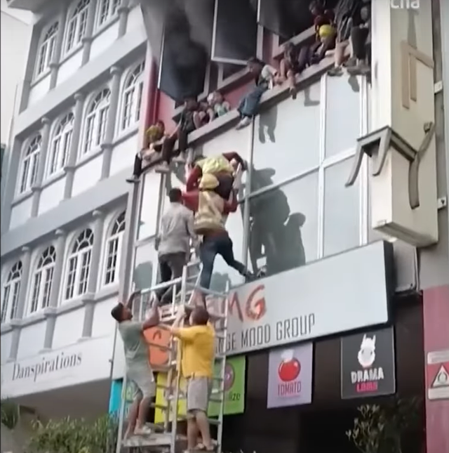 <p>Children are seen sitting on a ledge trying to escape the fire at their cooking school. Screengrab</p>